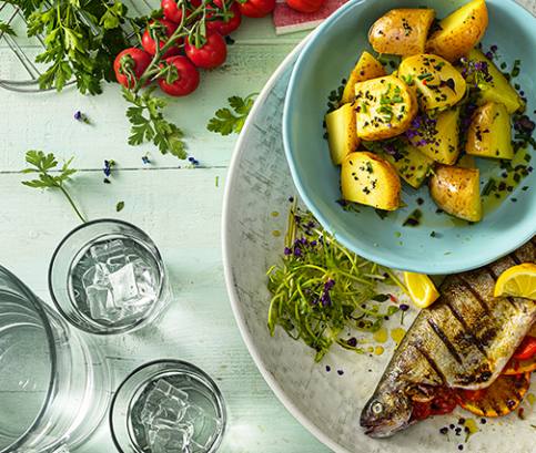 Grilovaný pstruh s rajčaty, pomeranči a salsou z černého rybízu, podávaný s pečenými brambory