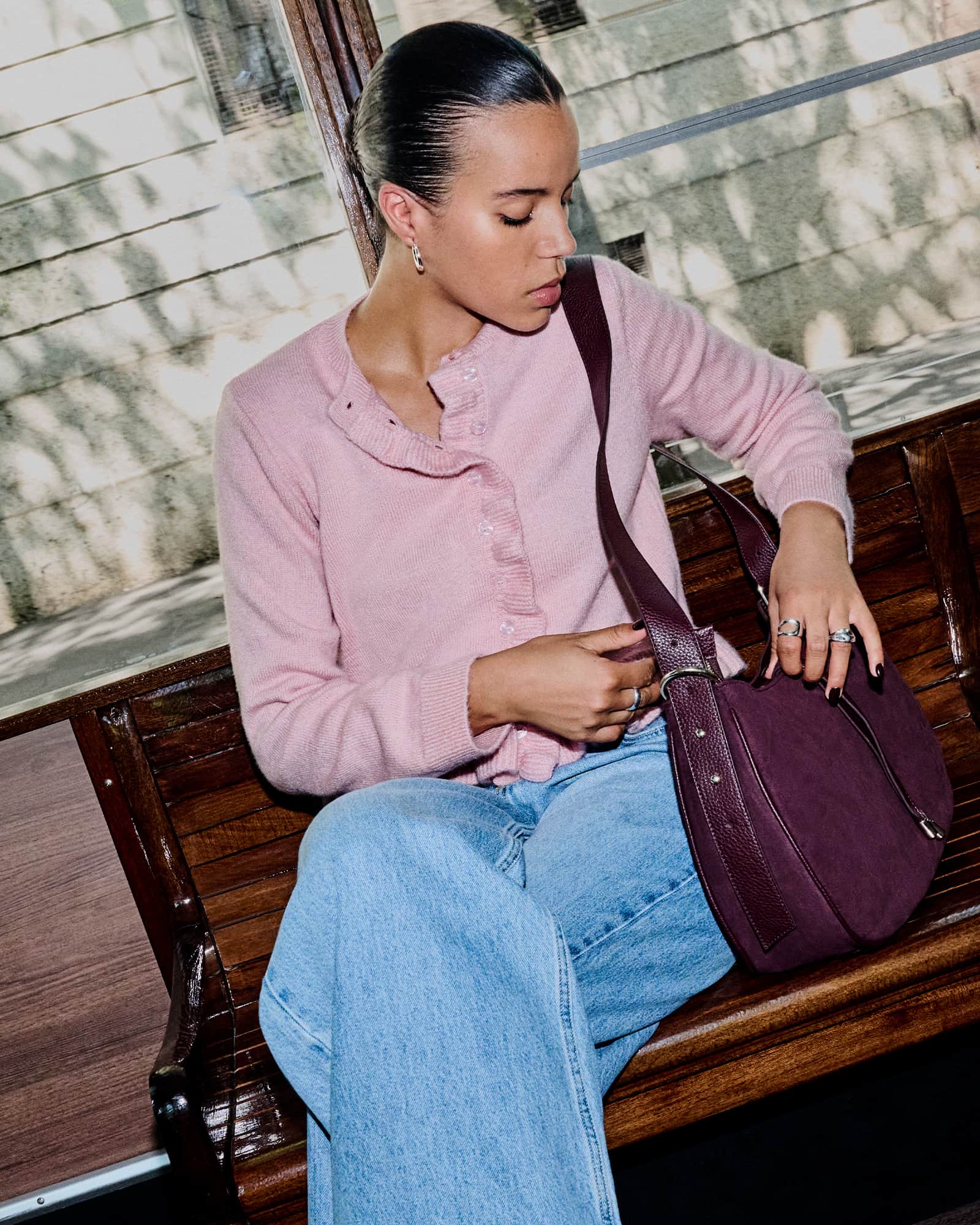 Long-sleeved pink frilly button-up cardigan.