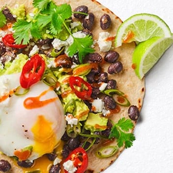 Crisp tostadas loaded with beans, avocado and a jammy poached egg