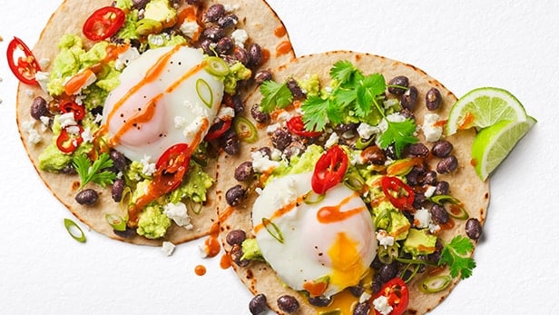 Crisp tostadas loaded with beans, avocado and a jammy poached egg