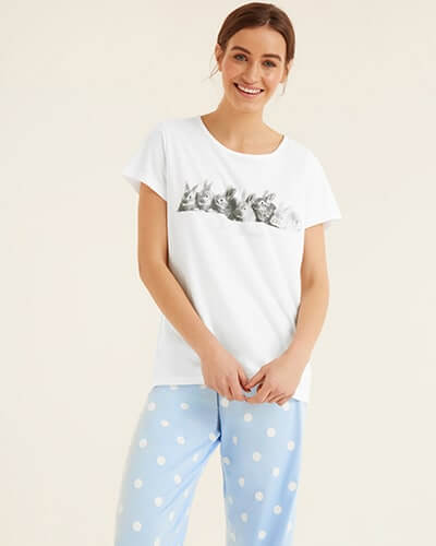 White short sleeve t-shirt with black and white bunnies across the chest and 'I'm all ears' written under. Paired with light blue PJ bottoms with white spots