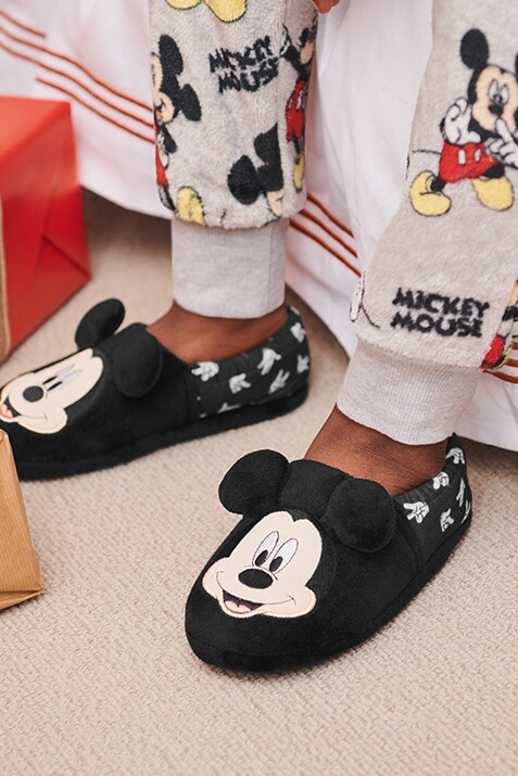  Black Mickey Mouse slippers with Mickey's face at the foot and white glove print around the ankle.