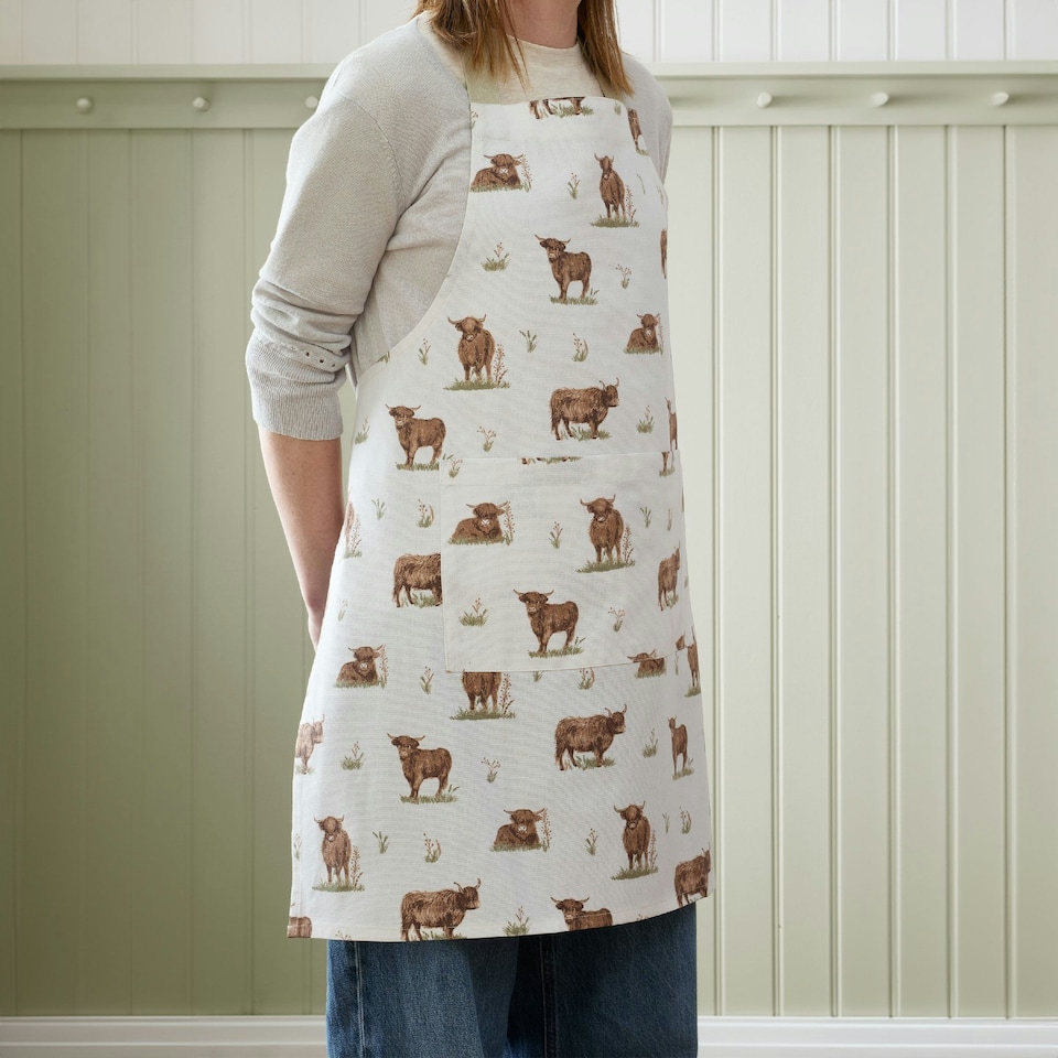 image 1 of Catherine Lansfield Angus Highland Cow Cotton Kitchen Adult Apron Natural Cream | Natural