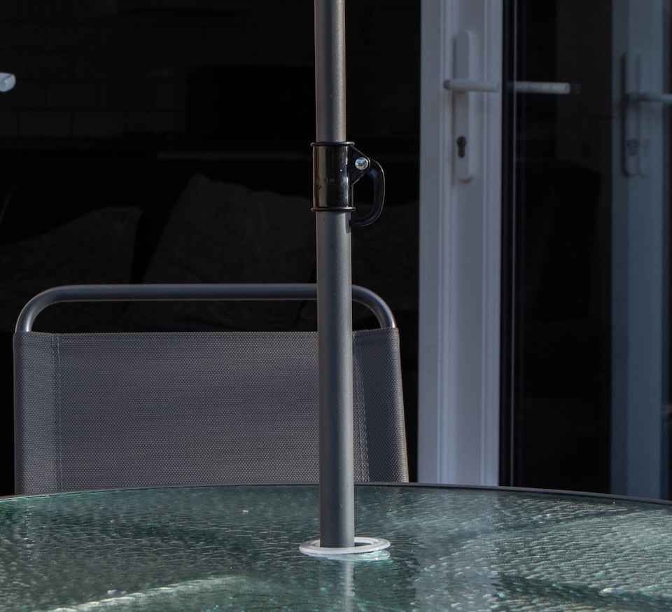 image 1 of Samuel Alexander Outdoor 4 Seater Round Glass Top Table and Chairs Patio Set with Parasol in Black