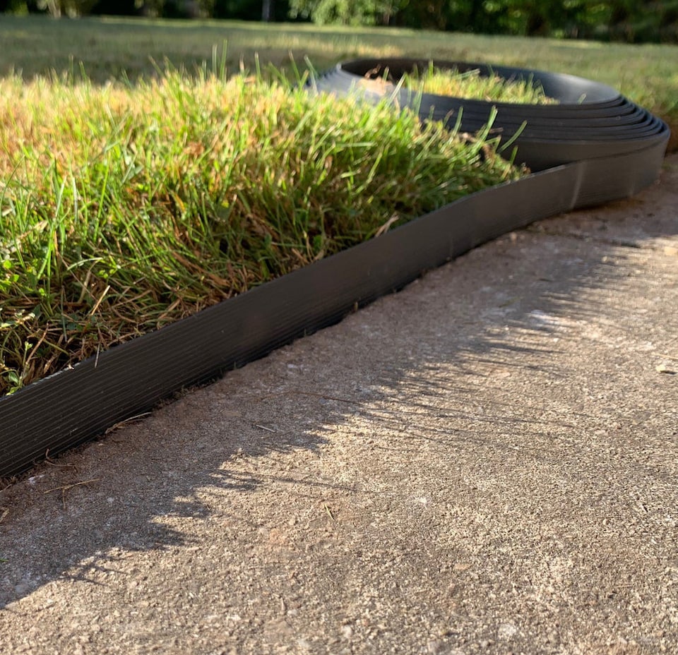 image 1 of Flexible Black Plastic Garden Lawn Edging Roll with 40 Pegs (10m)