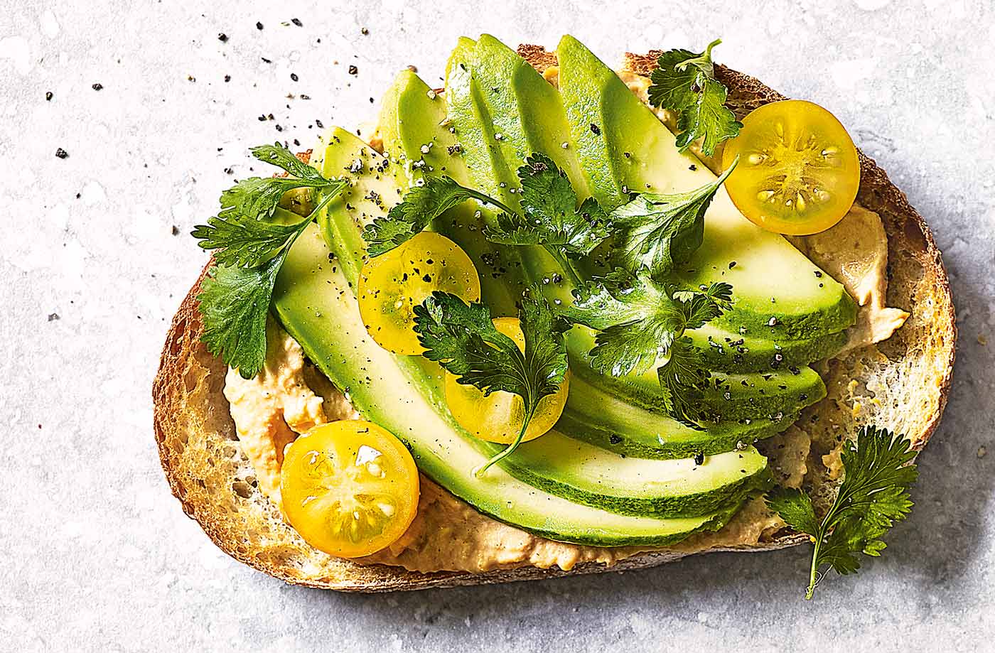 Houmous, avocado and yellow tomatoes toast topper