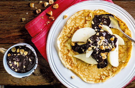 Image of "Pear with chocolate sauce and hazelnuts"