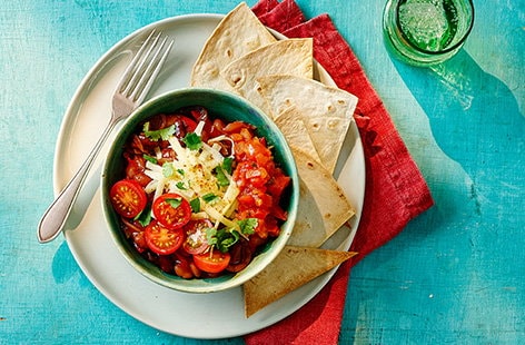 Image of "Quick bean chilli bowl with tortillas and cherry tomatoes"