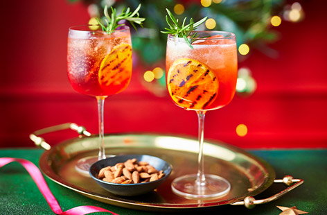 Image of "Charred orange and cranberry Aperol spritz"