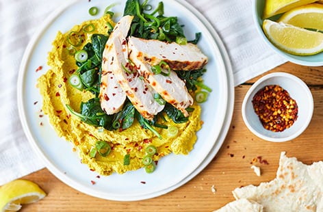 Image of "Grilled chicken with spinach and curried houmous"