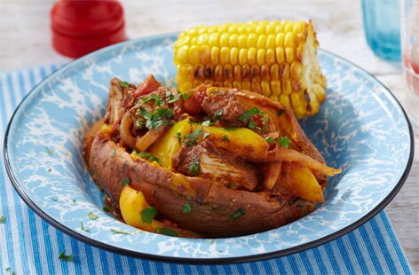 Image of "Jerk chicken stew with campfire corn on the cob"