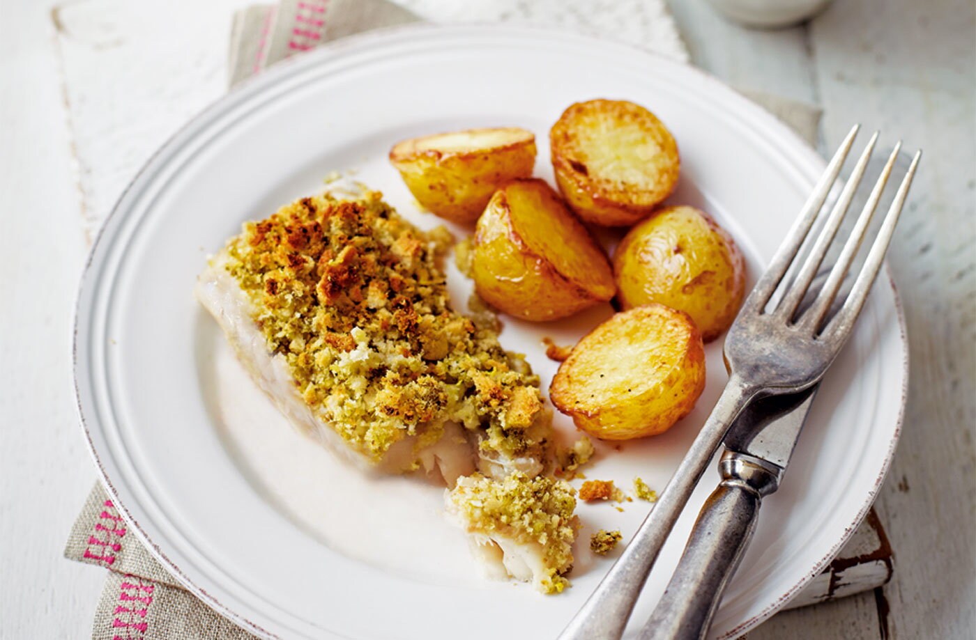 Lemon and pesto-crusted fish with potato wedges