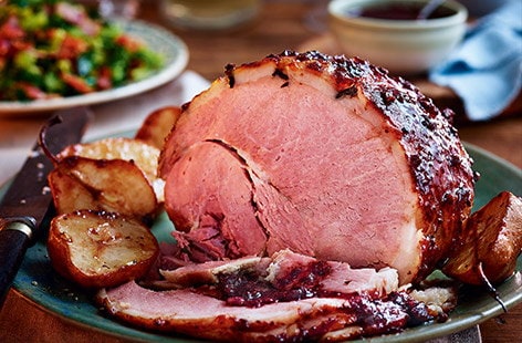 Image of "Baked ham with cranberry glaze, roasted pears and bacon greens"