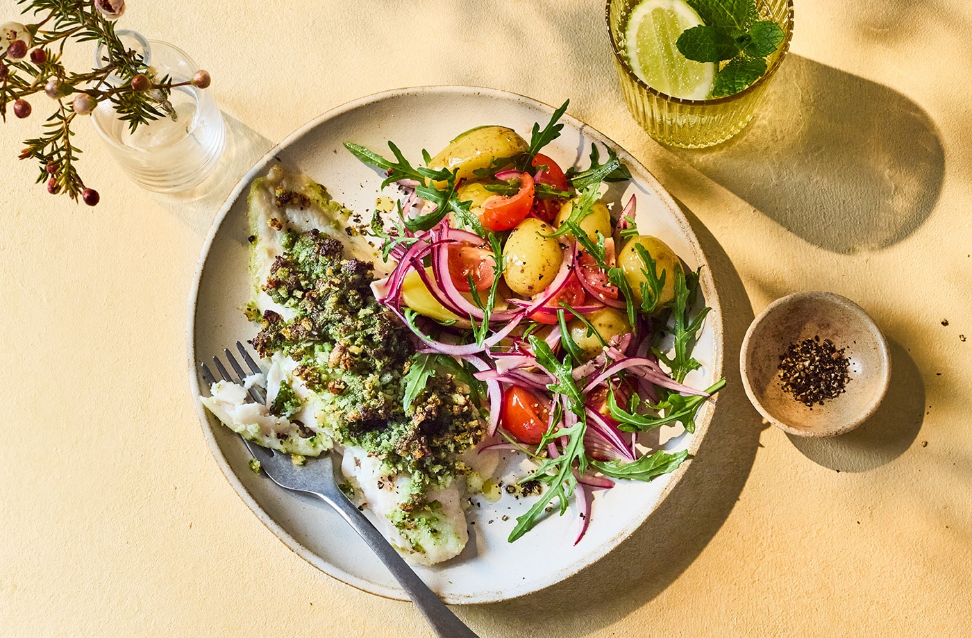 Pesto-crusted fish with potato, tomato and rocket salad