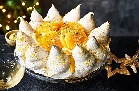 Image of "Orange, cardamom and pistachio pavlova crown"