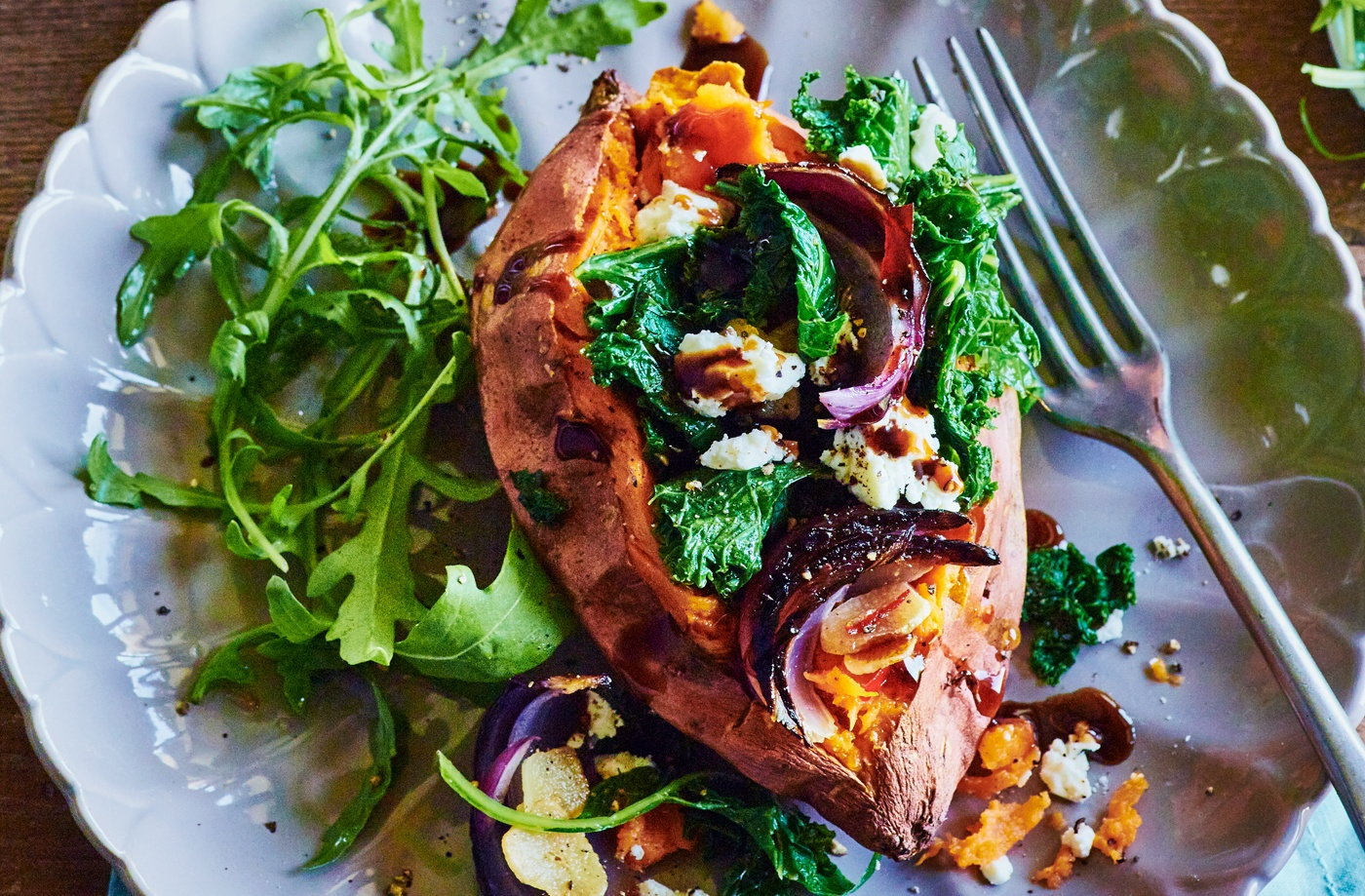 Baked sweet potatoes with kale, feta, chilli and onion