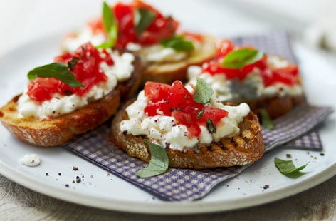 Image of "Tomato crostini topped with cottage cheese"