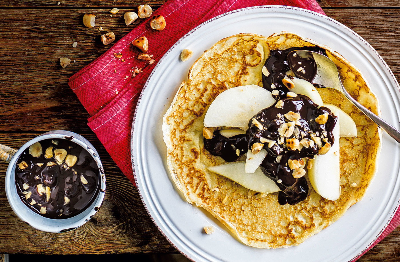 Pear with chocolate sauce and hazelnuts