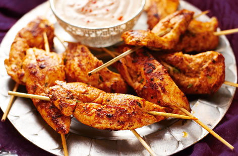 Image of "Spanish-style chicken skewers with spicy yogurt dipping sauce"