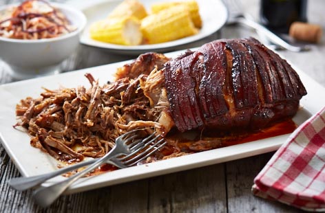 Pulled pork shoulder served with coleslaw and corn
