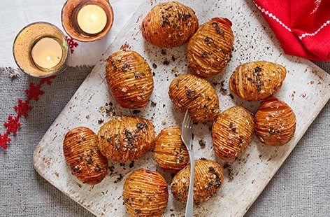 Image of "Sage and rainbow peppercorn hasselback potatoes"