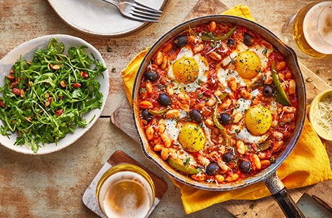 Image of "Baked eggs and Manchego with rocket and almond salad"