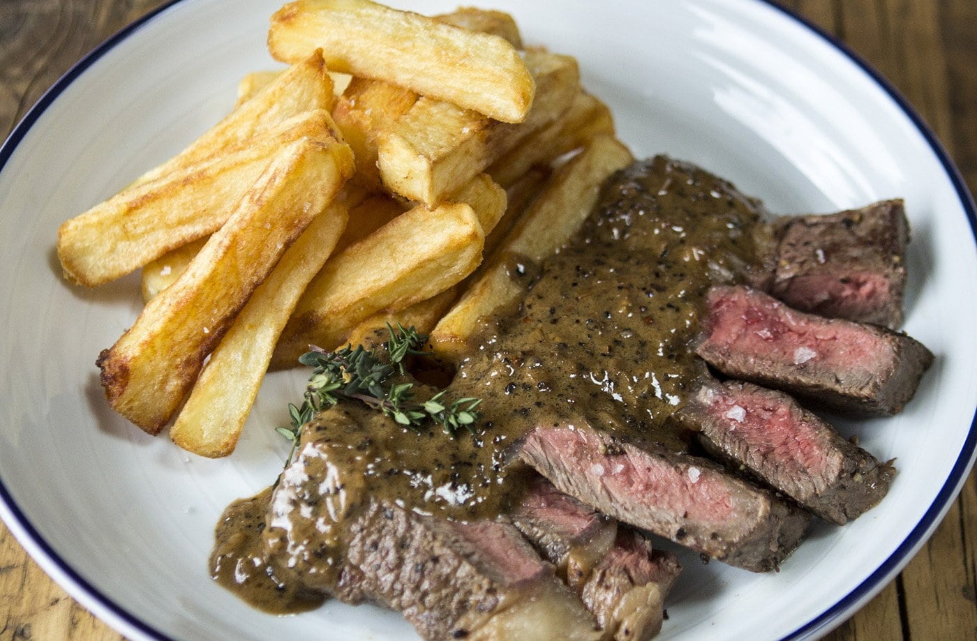 Ribeye steak and peppercorn sauce with chips