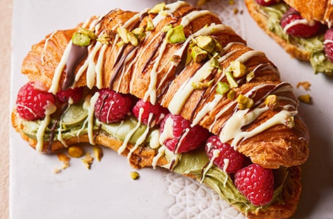 Drizzled croissants with pistachios and raspberries