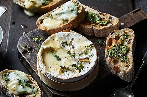 Image of "Baked smoked garlic cheese with pesto toasts"