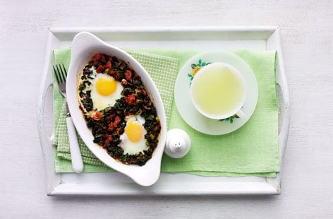 Image of "Baked eggs with tomatoes and black kale"