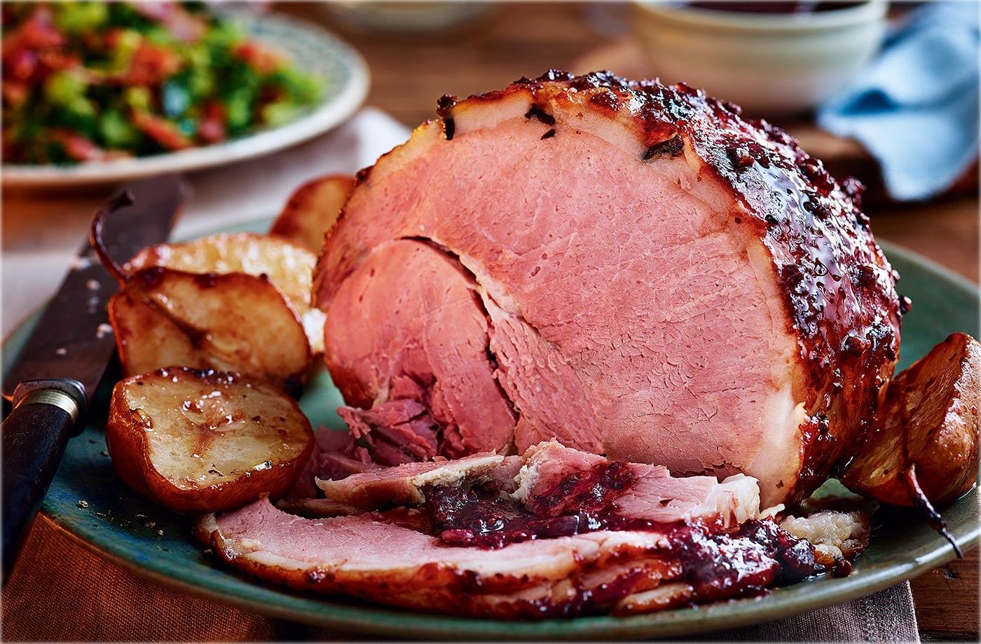 Baked ham with cranberry glaze, roasted pears and bacon greens