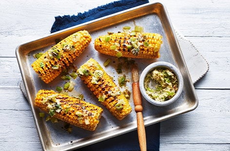 Image of "Corn on the cob with charred spring onion butter"
