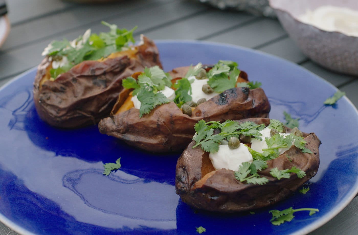 Ember-roasted sweet potatoes with cream cheese and capers