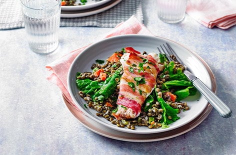 Image of "Bacon-wrapped fish with creamy lentils"